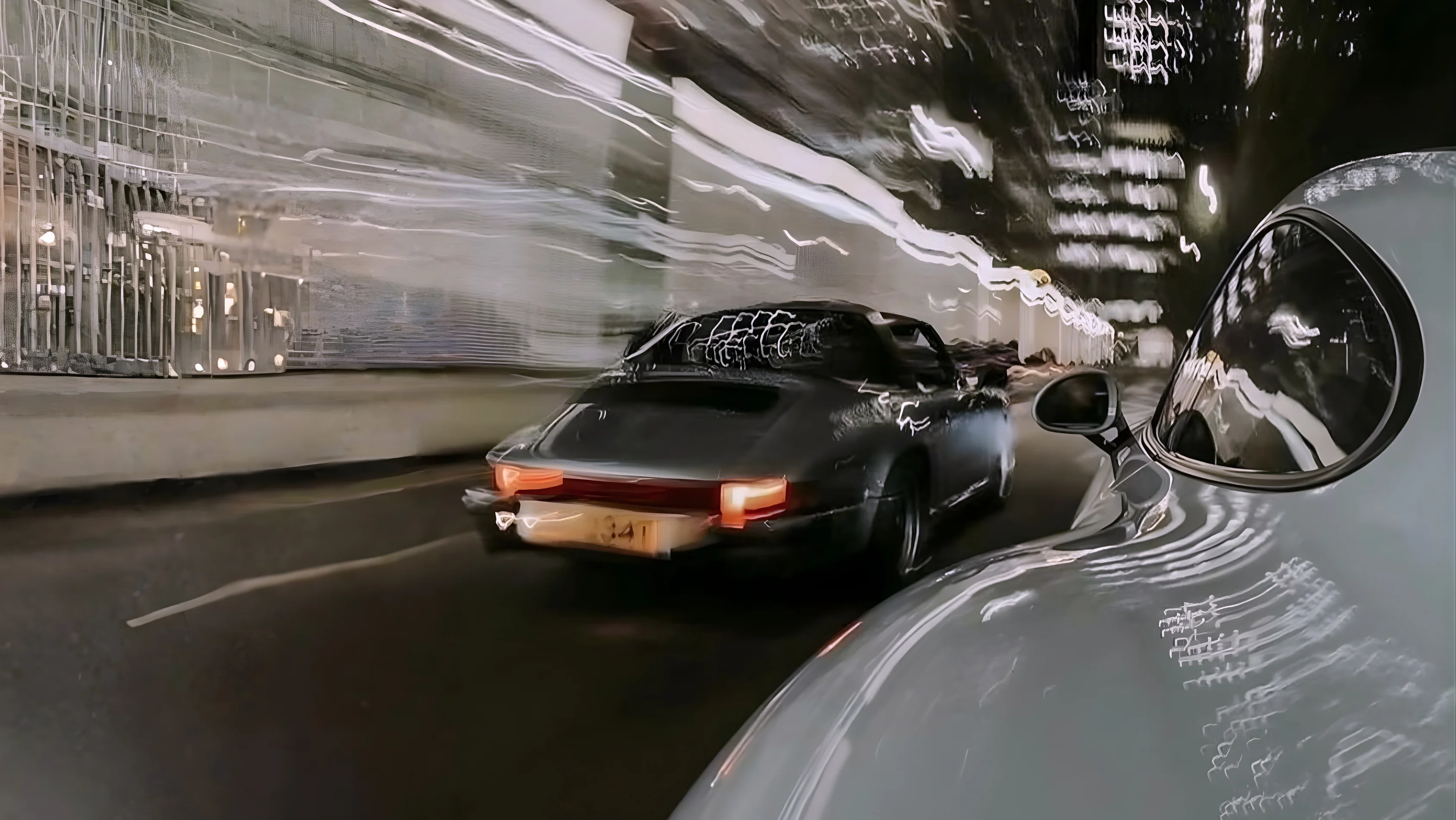 Two sports cars driving at night with motion blur and streaks of light along the road.
