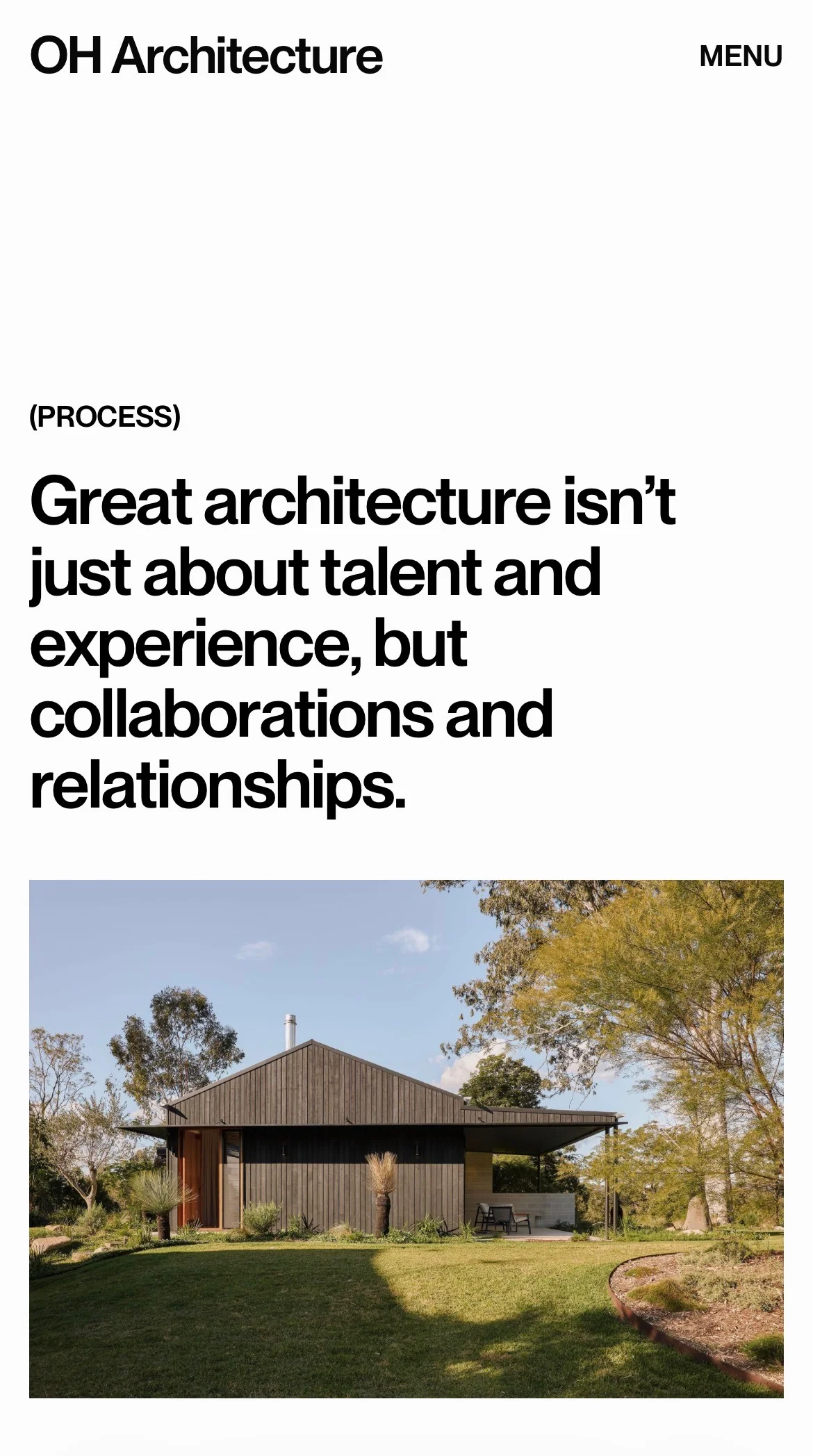 Modern single-story wooden house with a dark exterior, surrounded by a garden and trees under a clear sky.