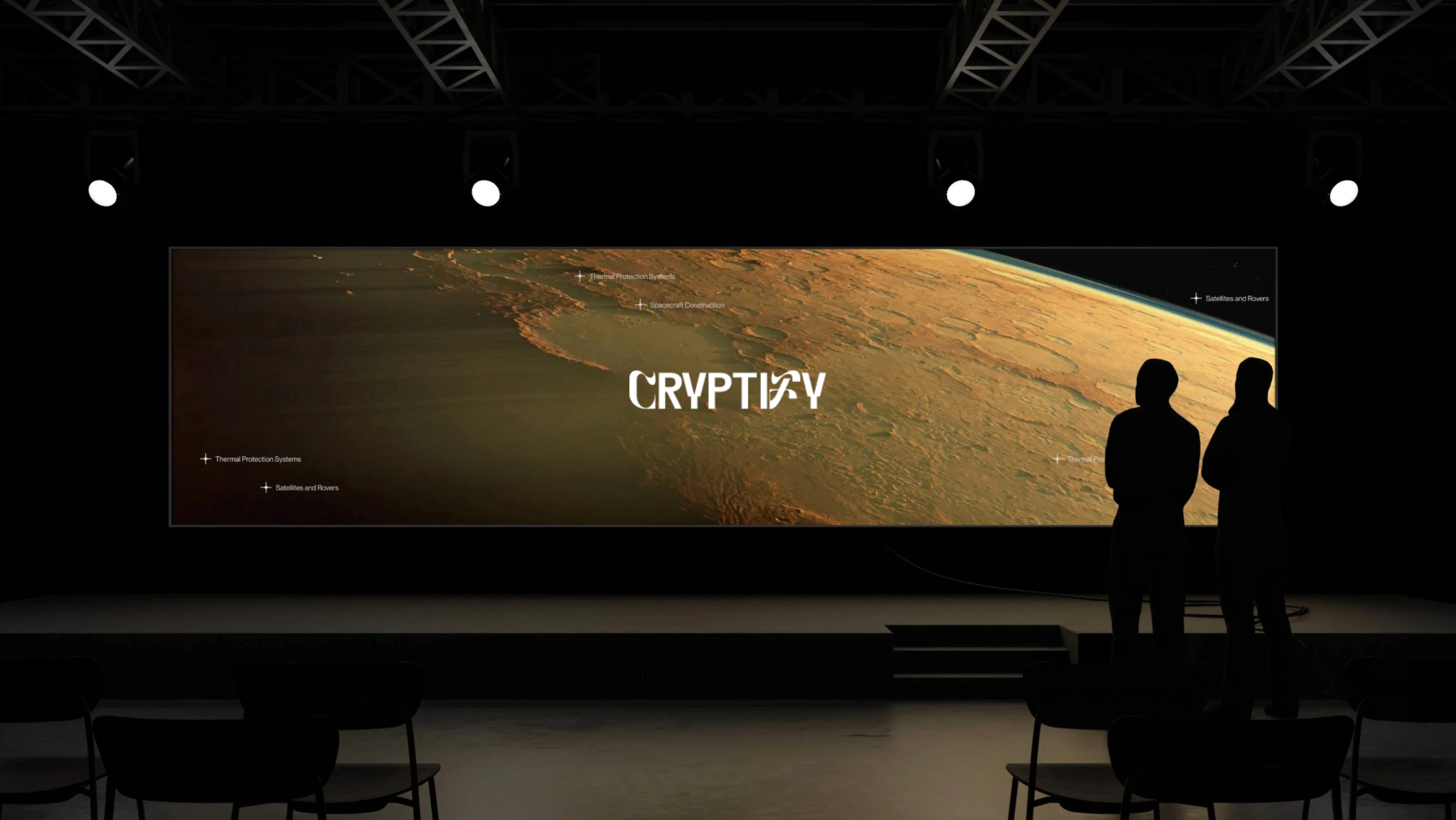 Two silhouetted figures standing in a dark room looking at a large illuminated screen displaying a planetary surface and the word 'CRYPTIFY'.